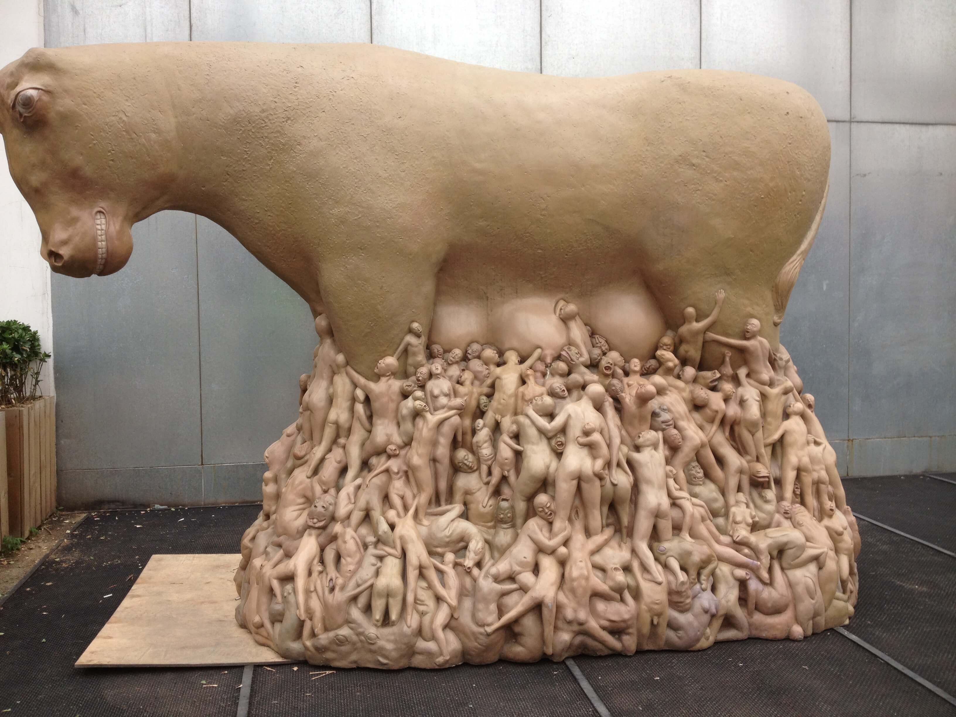 Beijing art. Statue of cow with humans suckling