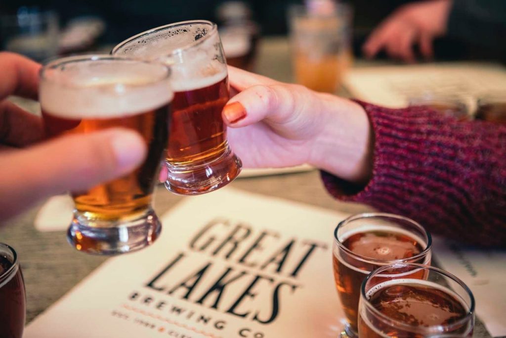 People toasting with beer on a Brewery road trip