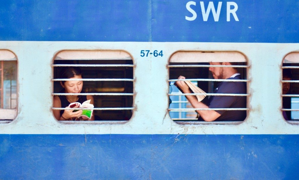 A couple reading books on a train 