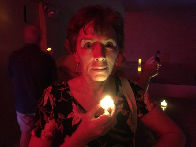 A visitor to St. Parrick's Basilica holding a candle